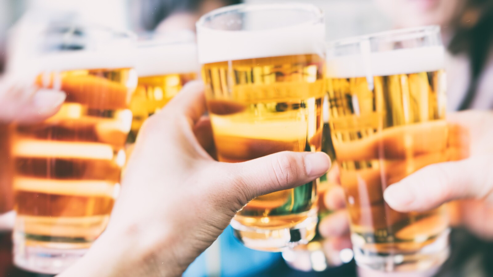 Des personnes trinquent avec leur verre de bière.