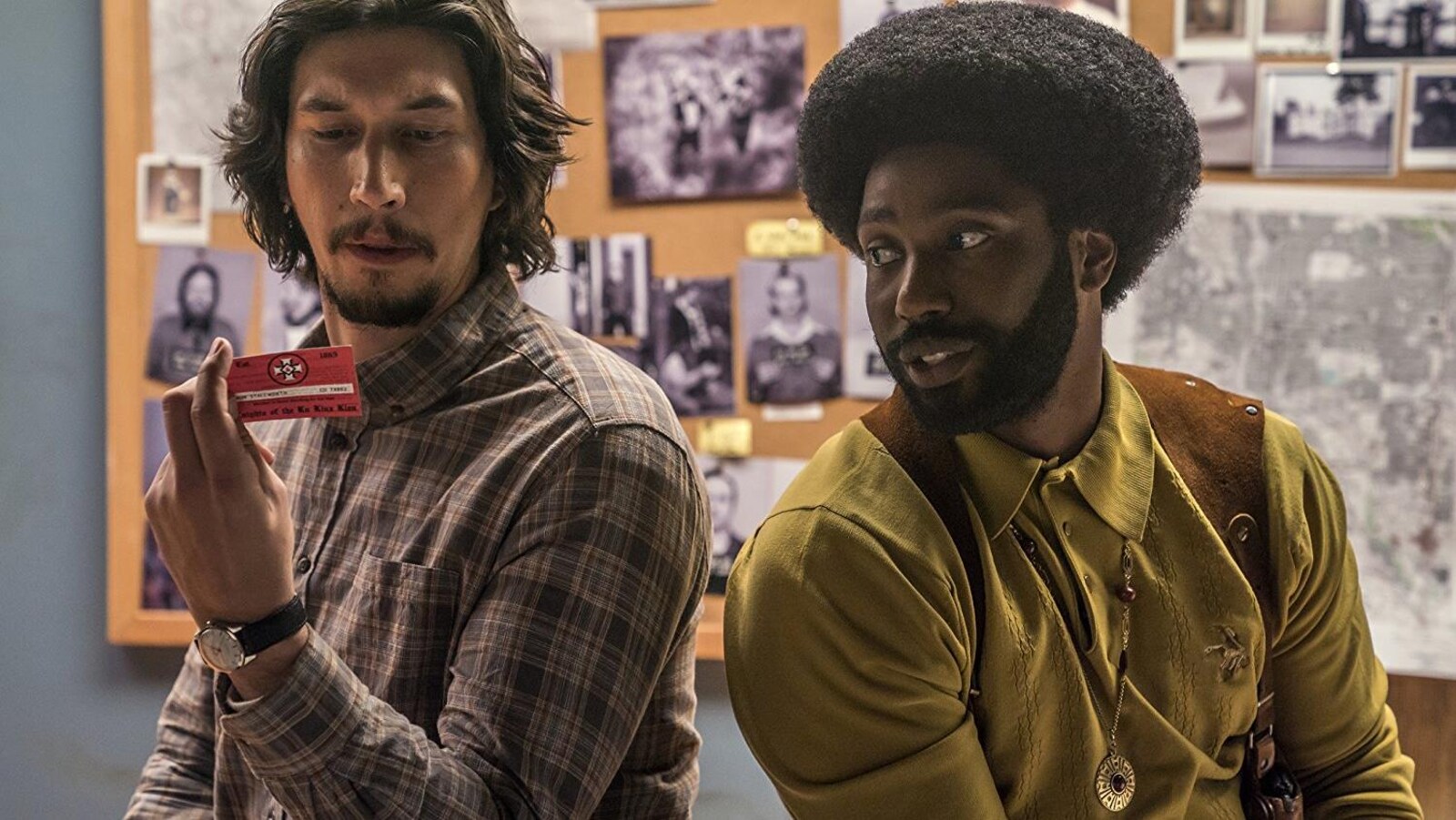 Adam Driver et John David Washington regardent une carte de visite dans une scène du film «Opération infiltration<».