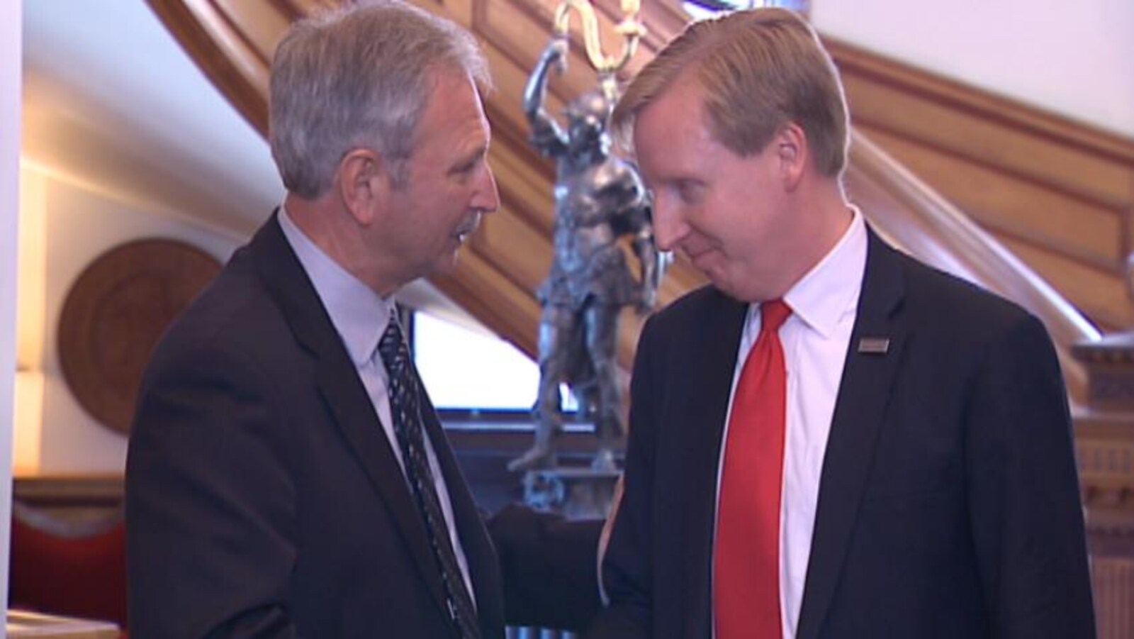Blaine Higgs s'entretient avec Dominic Cardy dans le hall de l'Assemblée législative du Nouveau-Brunswick