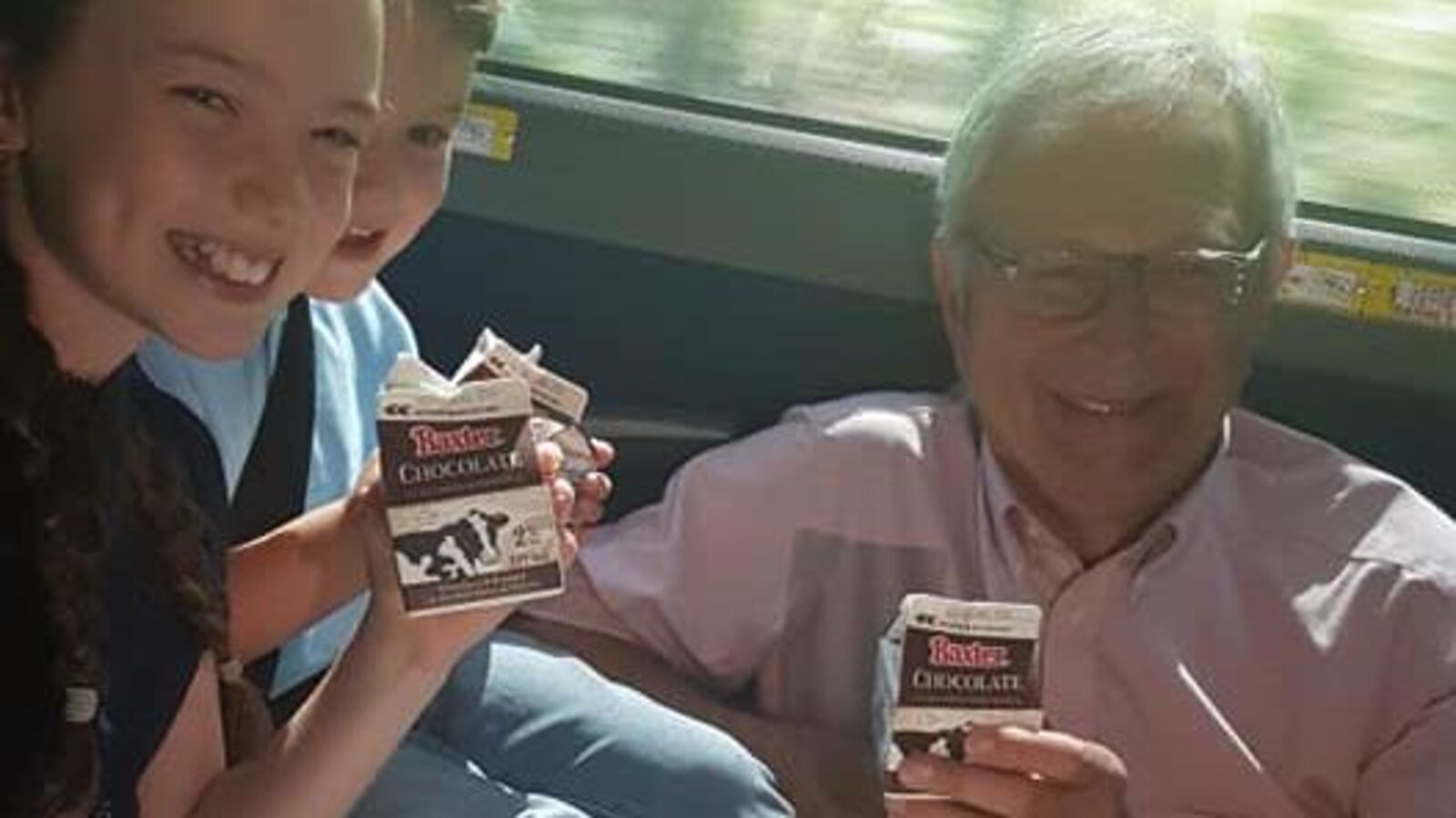 Blaine Higgs boit du lait au chocolat avec deux enfants.