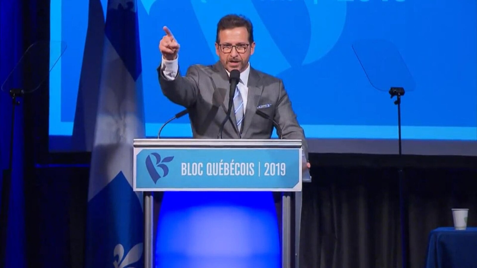 Yves-François Blanchet sur scène, le doigt levé, lors de son discours.