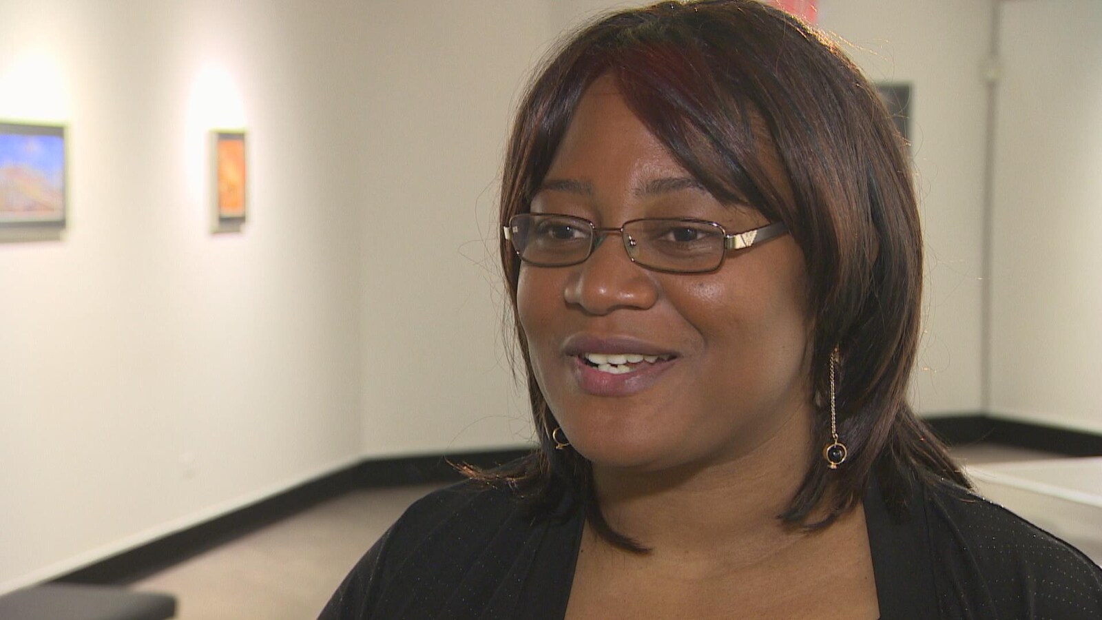 Une femme parle à une personne hors champ dans une galerie d'art au Centre culturel franco-manitobain.