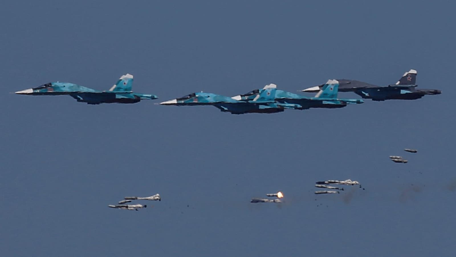 Des avions Sukhoi Su-34 russes larguent des bombes lors de manoeuvres aériennes.
