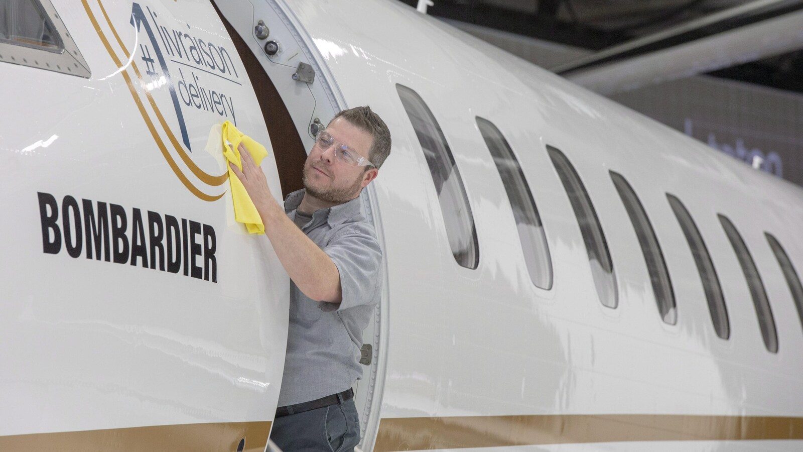 Un homme passe un linge sur la carlingue d'un avion.