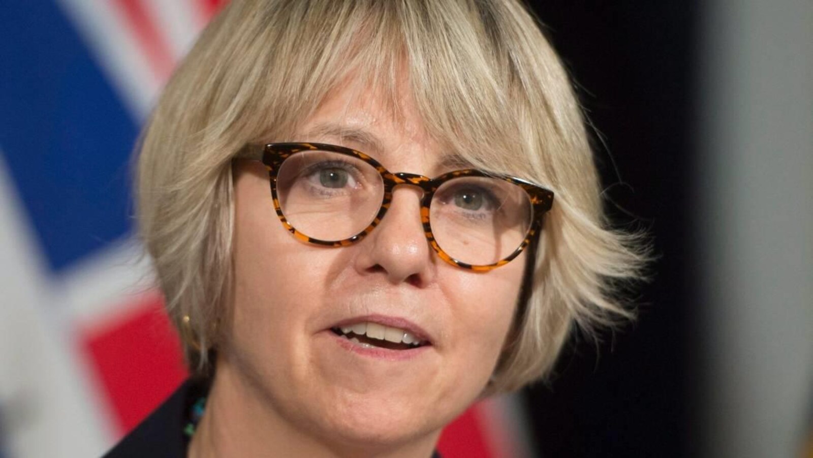 La Dre Bonnie Henry a les cheveux blonds et de grandes lunettes arrondies.