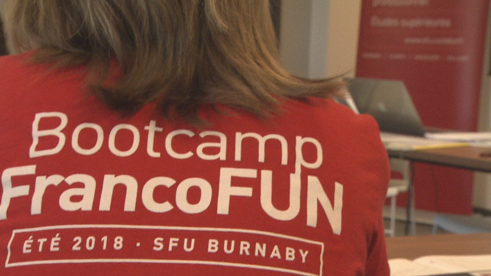 On voit une femme de dos porter le t-shirt rouge du bootcamp.