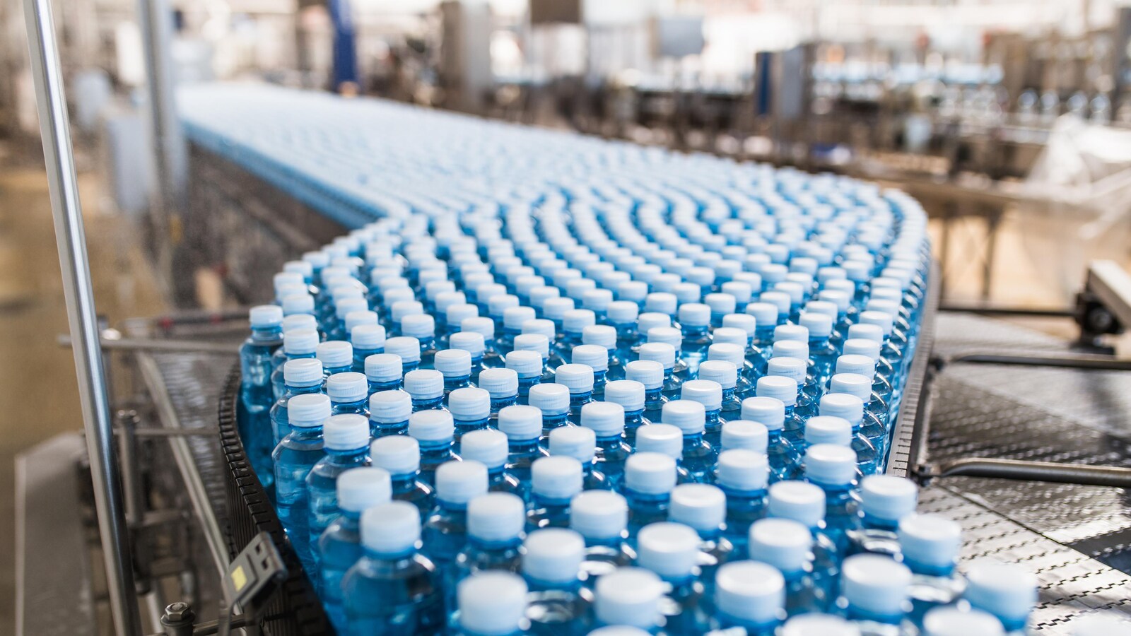 Des bouteilles de plastique dans un convoyeur.