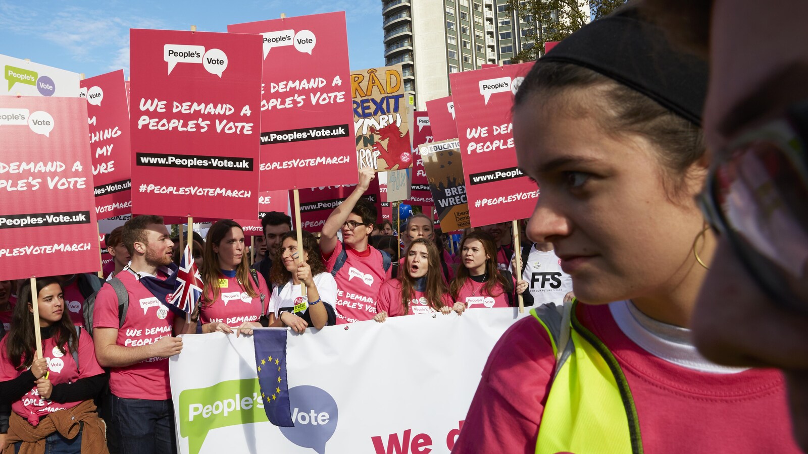Des manifestants anti-Brexit, vêtus de rose, portent des pancartes sur lesquelles ils demandent une consultation populaire.