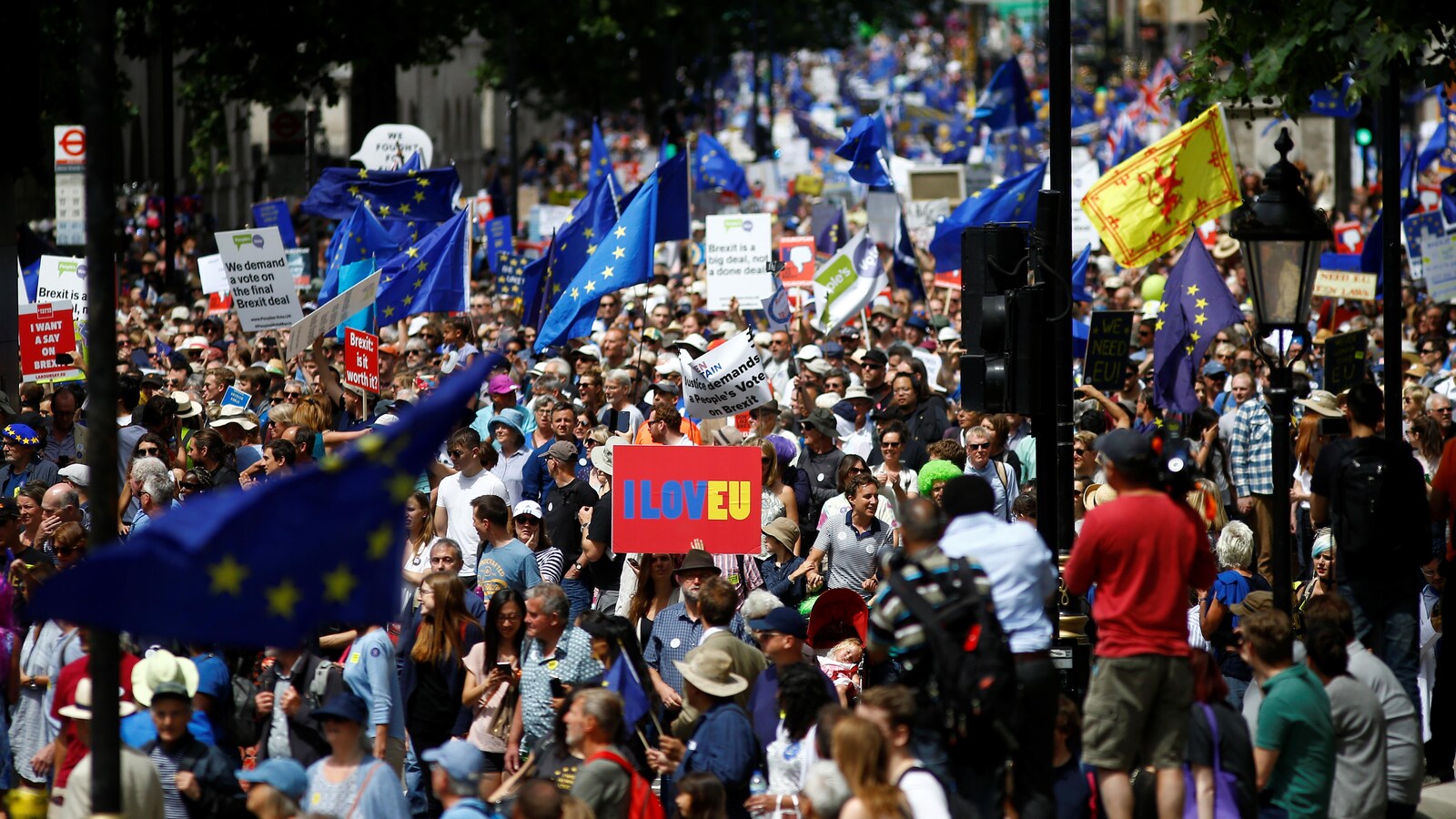 Des gens marchent dans une rue de Londres et brandissent le drapeau de l'Union européenne.
