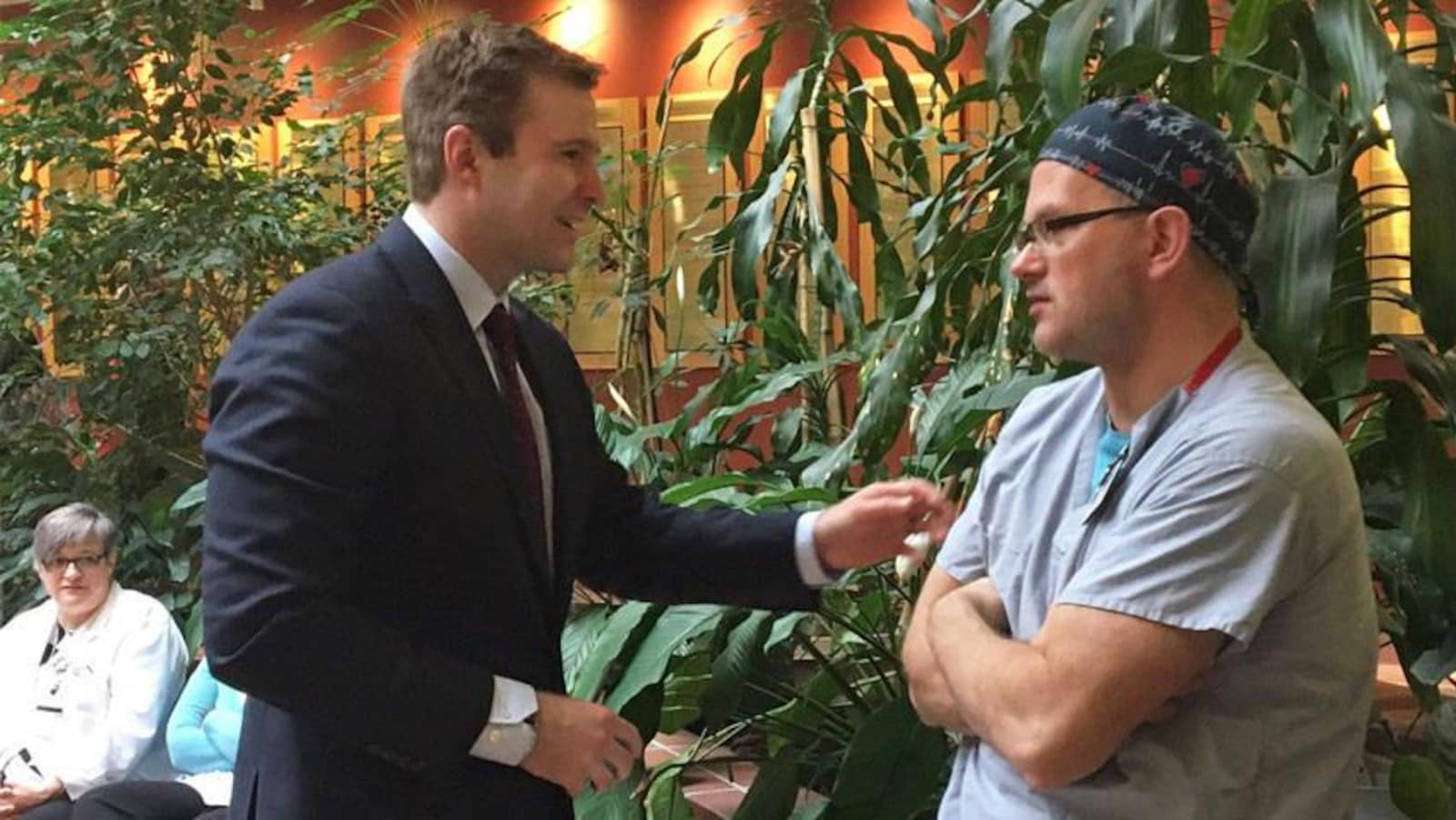 Le premier ministre du Nouveau-Brunswick, Brian Gallant, discute avec un employé à l'hôpital de Saint-Jean, où il a annoncé l'embauche de 25 nouveaux médecins spécialistes pour l'ensemble de la province.