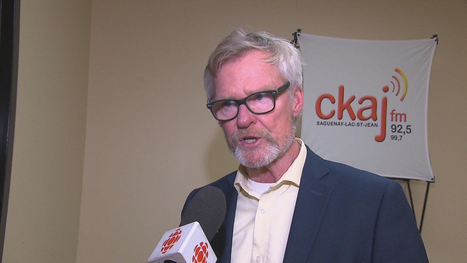 Bruno Cantin en entrevue devant une affiche de CKAJ.