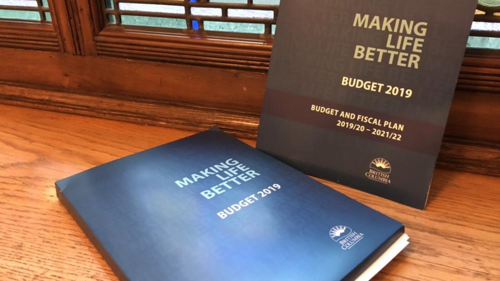 Des documents du budget sont déposés sur le rebord d'une fenêtre.