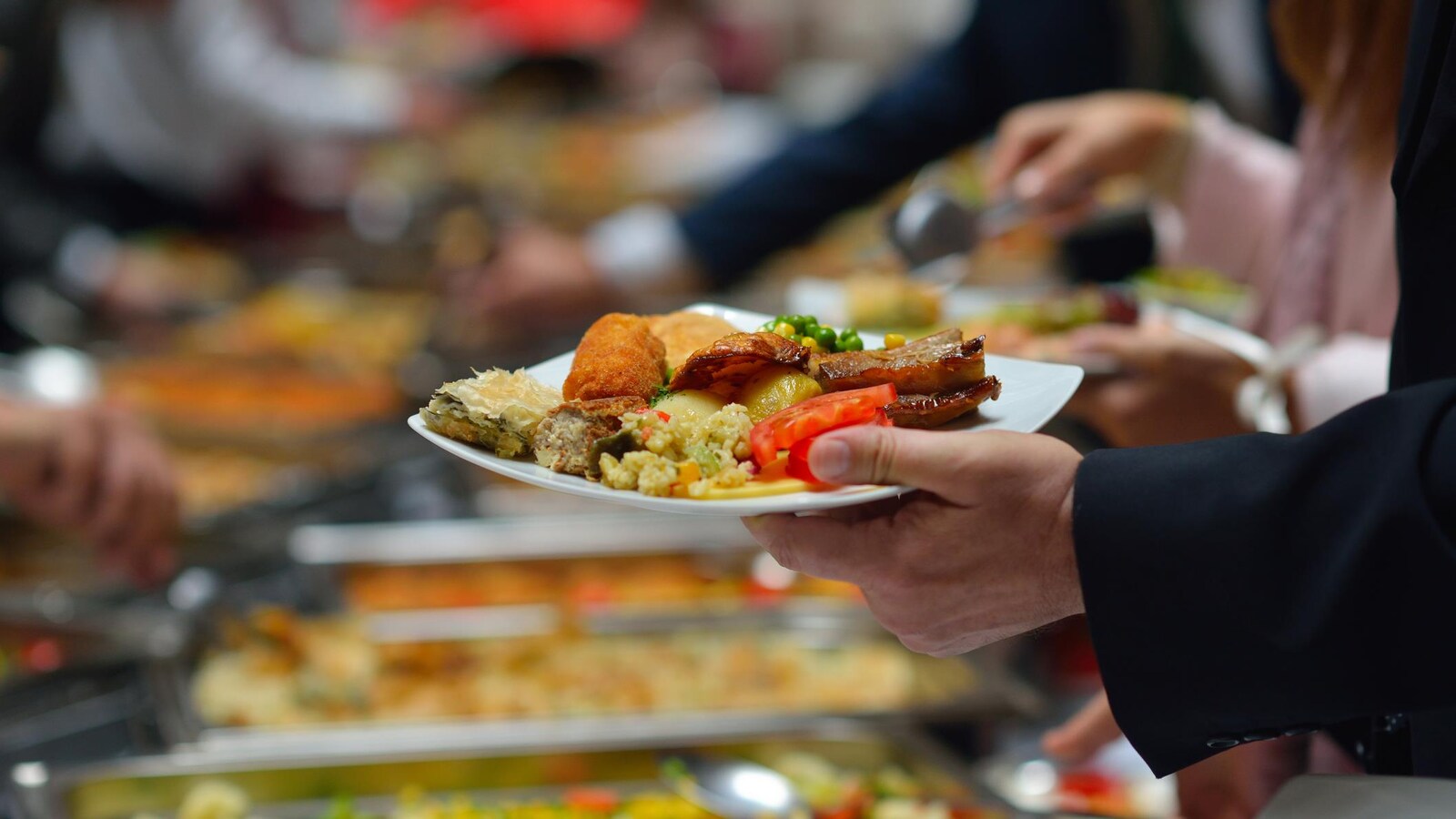 Des gens se servent dans un buffet.