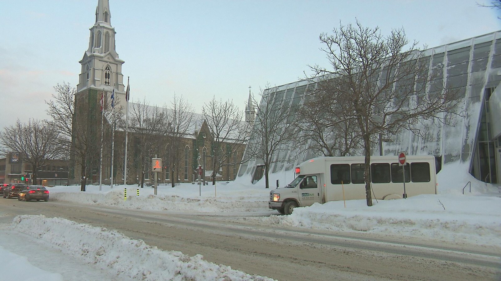 Un autobus de transport adapté à Rimouski circule dans une rue enneigée.