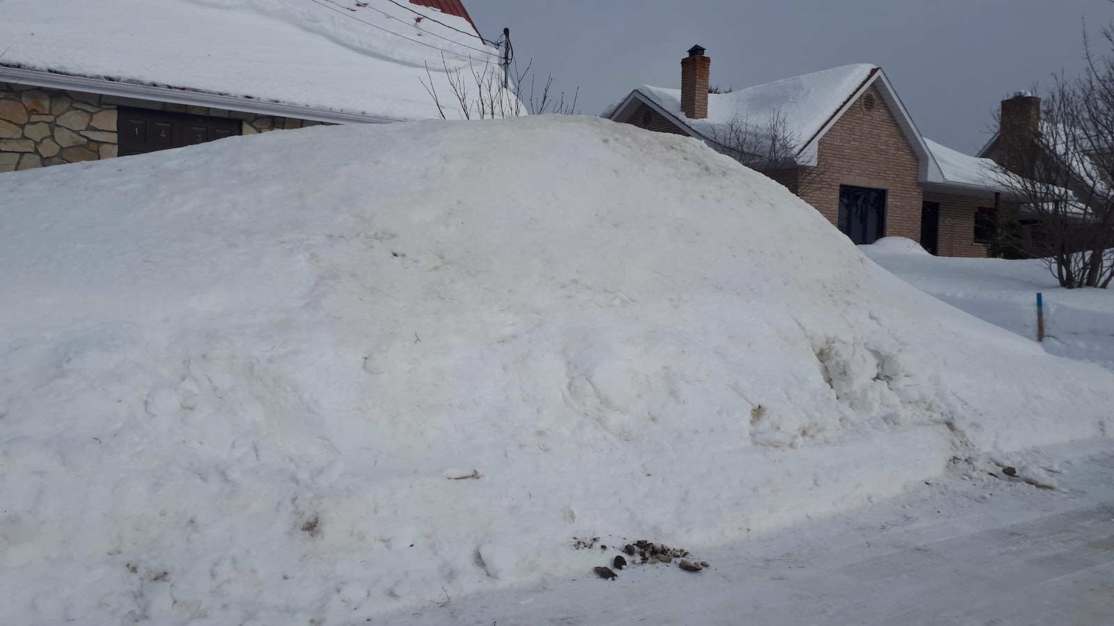 Une butte de neige cache une maison.