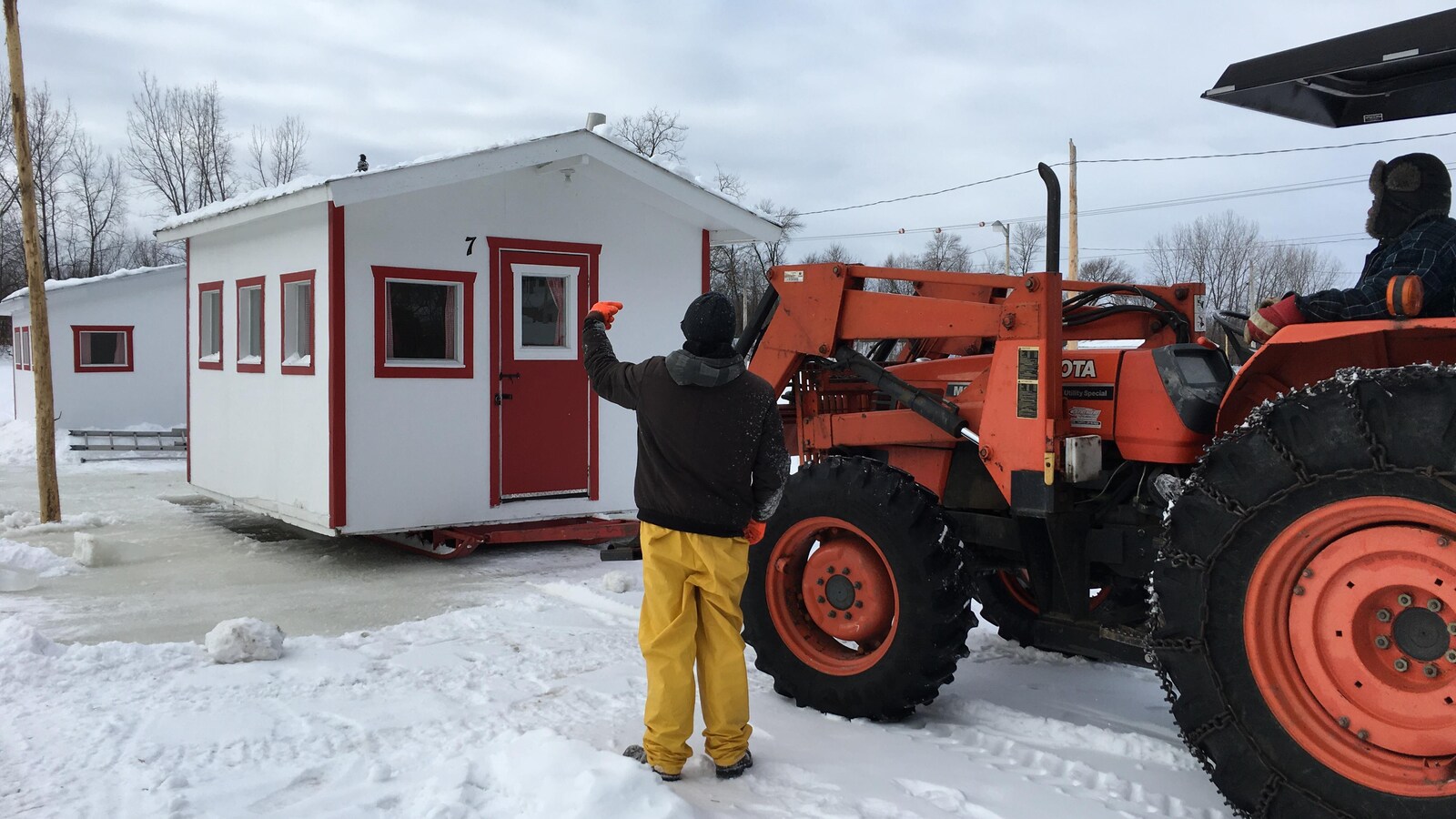 Tracteur qui dépose une cabane sur la glace à Sainte-Anne-de-la-Pérade