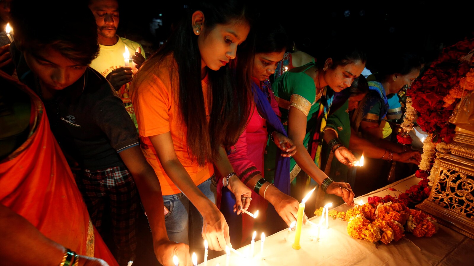 Des gens allument des bougies sur un monument commémoratif lors d'une vigile en mémoire des 41 paramilitaires tués dans un attentat suicide la semaine dernière à Kolkata.