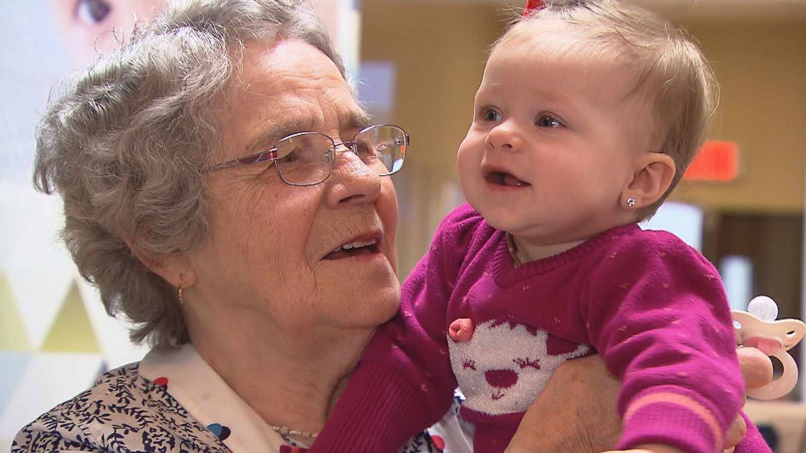 Une aînée tient un bébé dans ses bras.