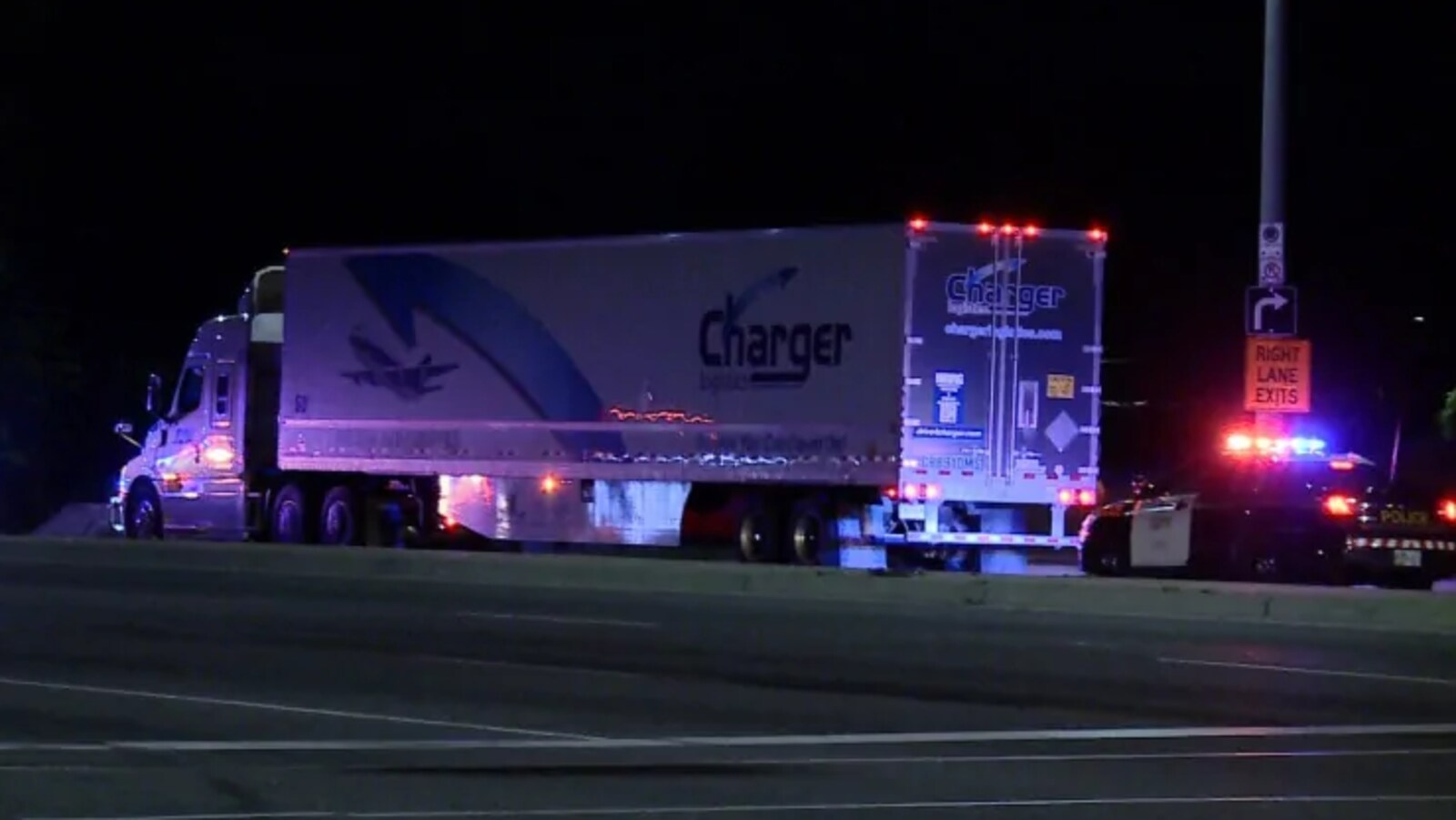 Photo d'un camion immobilisé sur la route la nuit; une autopatrouille aux gyrophares allumés est derrière le camion.