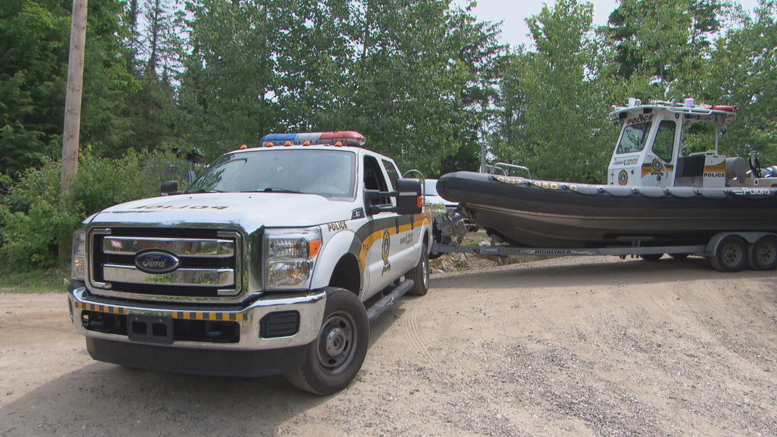 Une camionnette de la Sûreté du Québec avec à sa remorque un bateau.