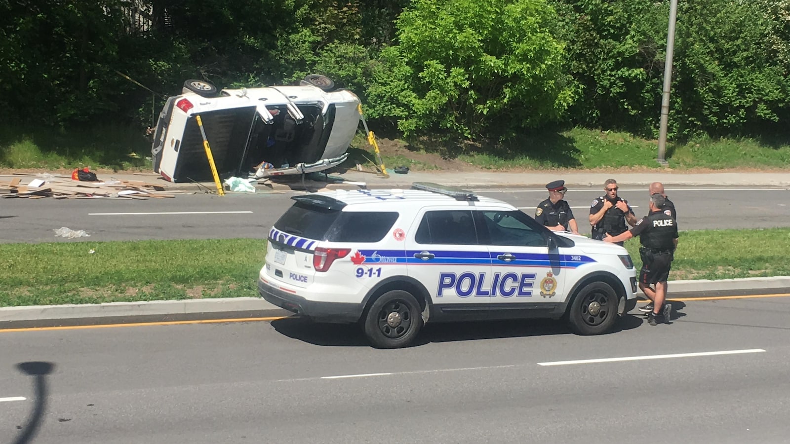 Une voiture de police devant une camionnette accidentée.
