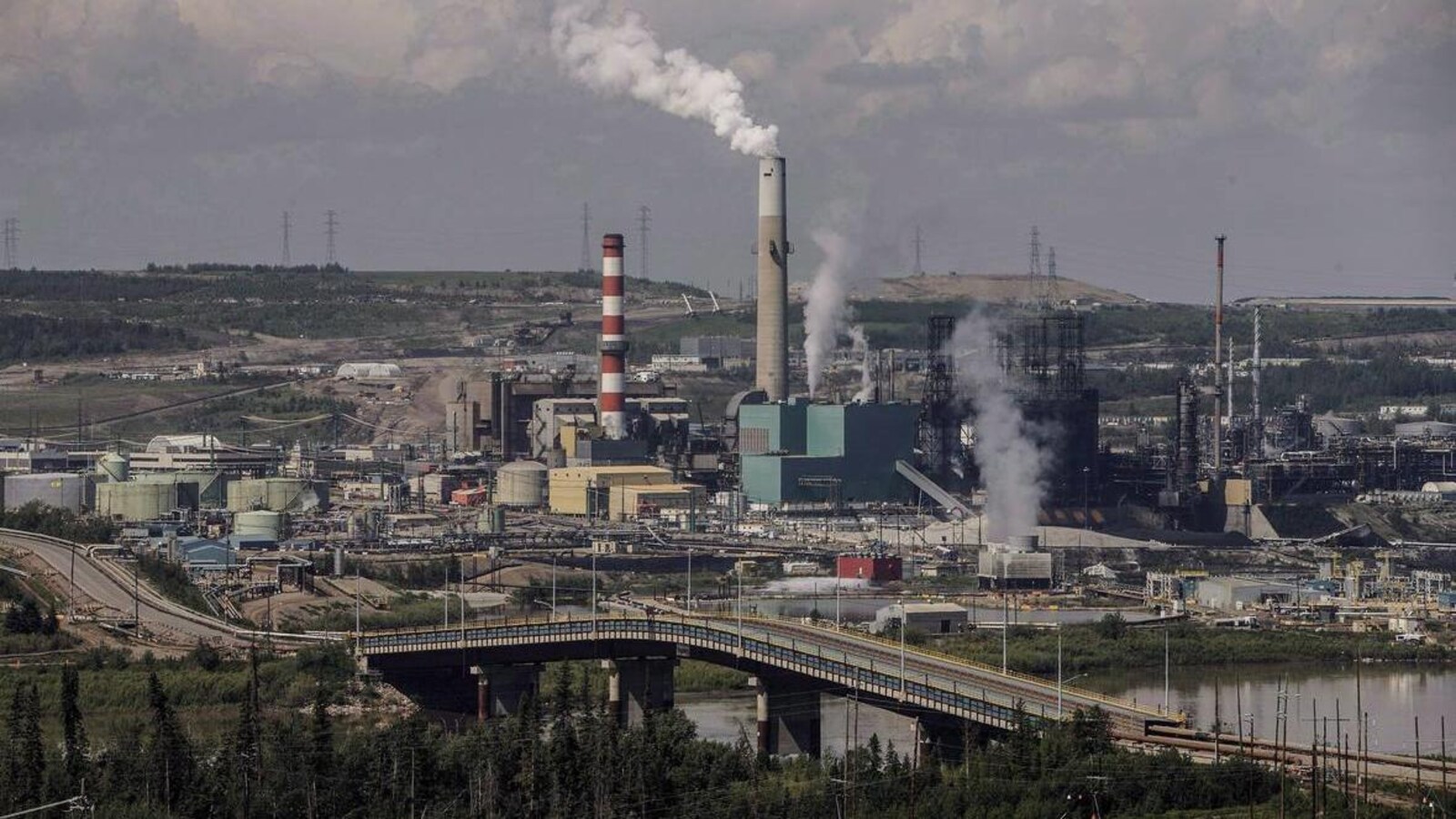 Dans l'image, des fumées qui s'échappent des usines dans la région de Fort McMurray