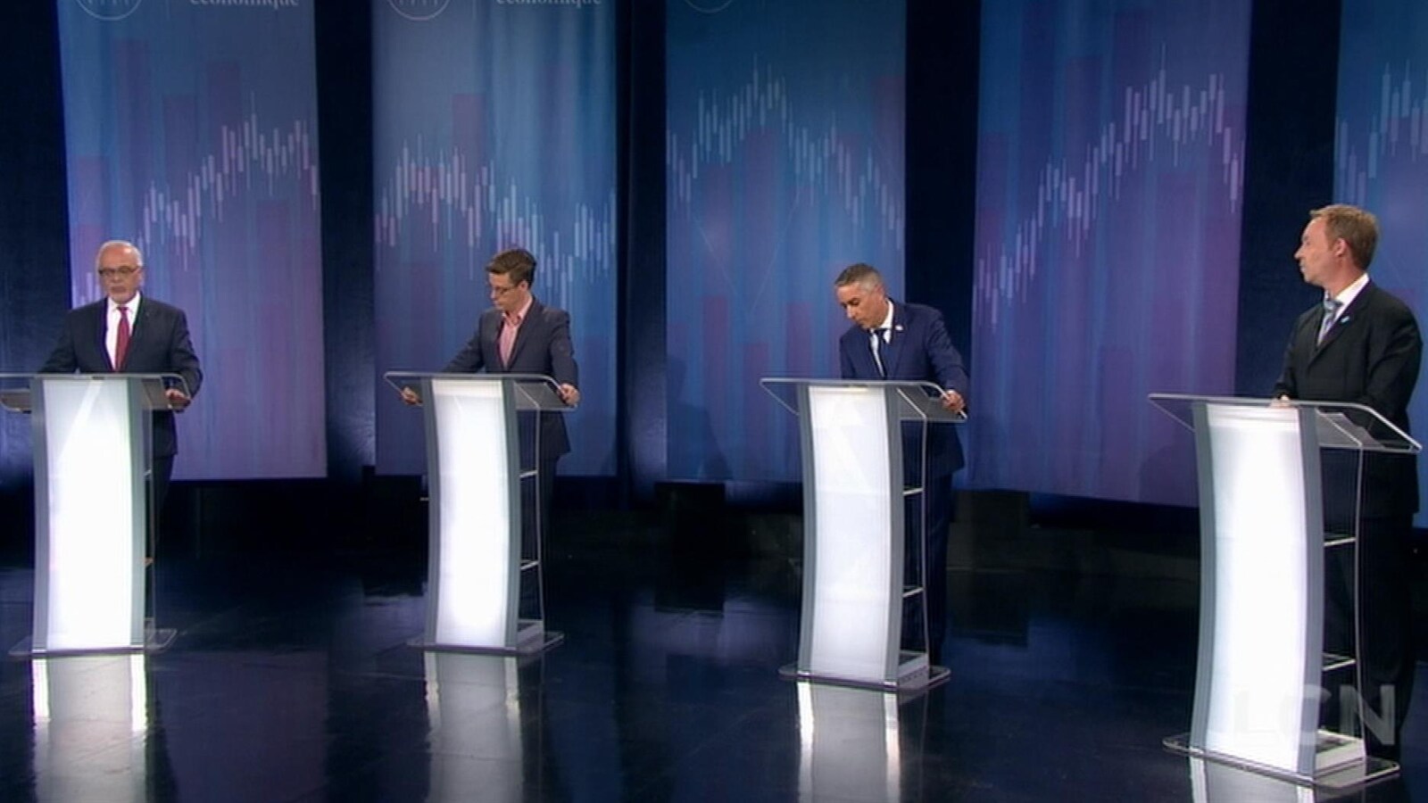 Les quatre candidats se tenant derrière leur podium respectif.