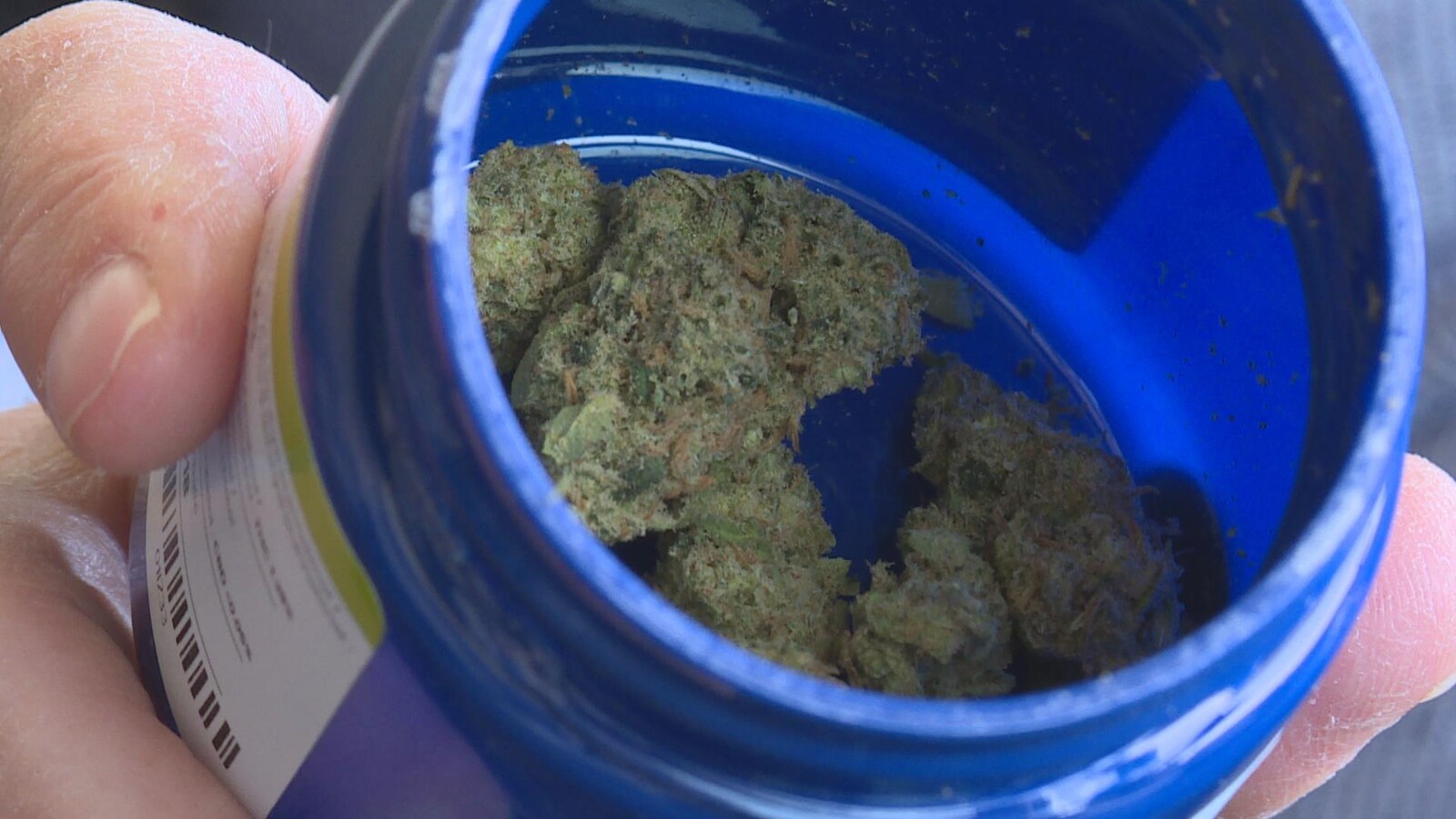 Une boîte de cannabis médicinal ouverte avec de l'herbe à l'intérieur.