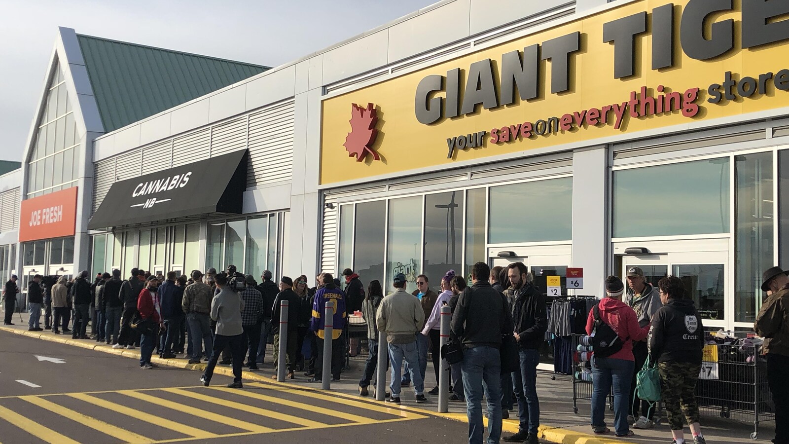 Plusieurs dizaines de personnes font la file pour entrer au magasin.
