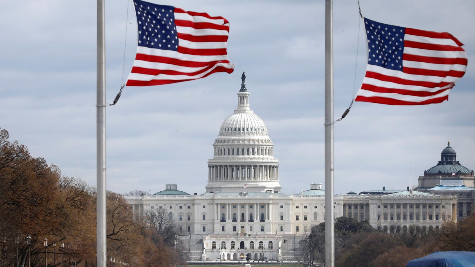 Vue panoramique du Capitole, derrière des drapeaux des États-Unis.