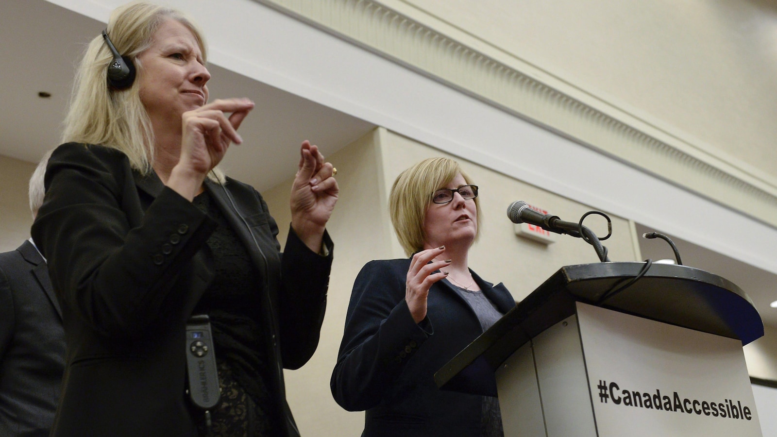 La ministre Carla Qualtrough est accompagnée d'une interprète qui traduit ses propos en langue des signes.