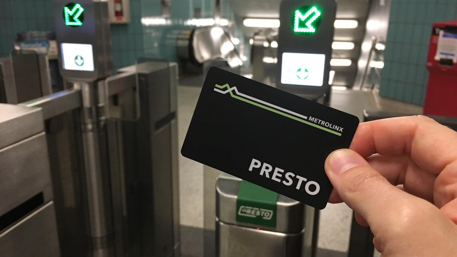 Photo d'une carte noire portant le logo « Presto » devant une porte d'entrée du métro.