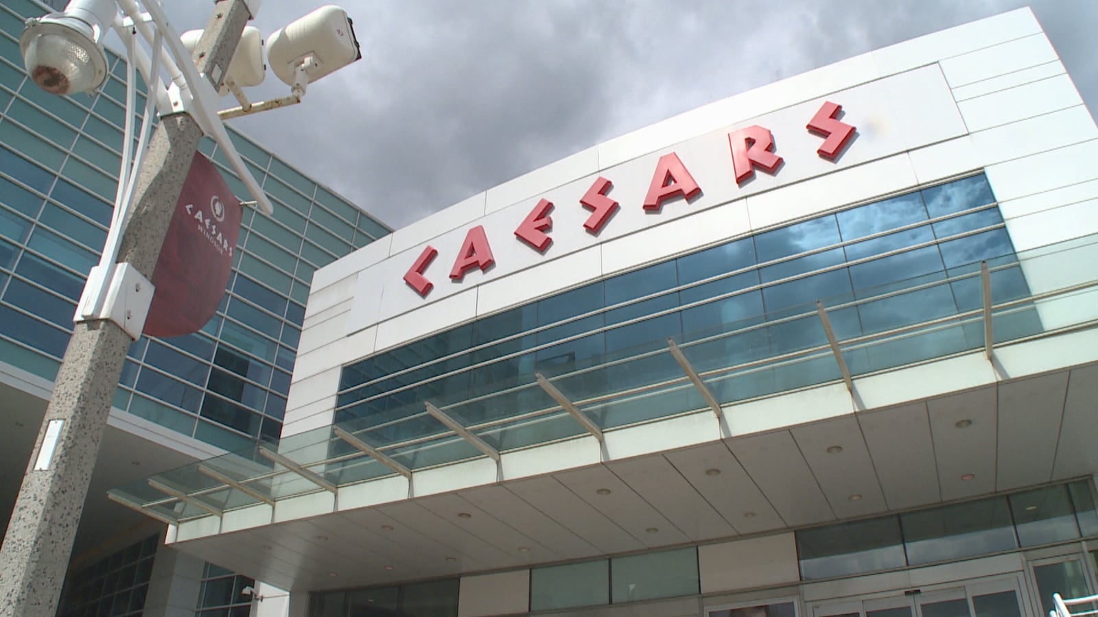 Vue en contre-plongée d'une entrée du casino. On voit les lettres en rouge du nom du casino CAESARS.