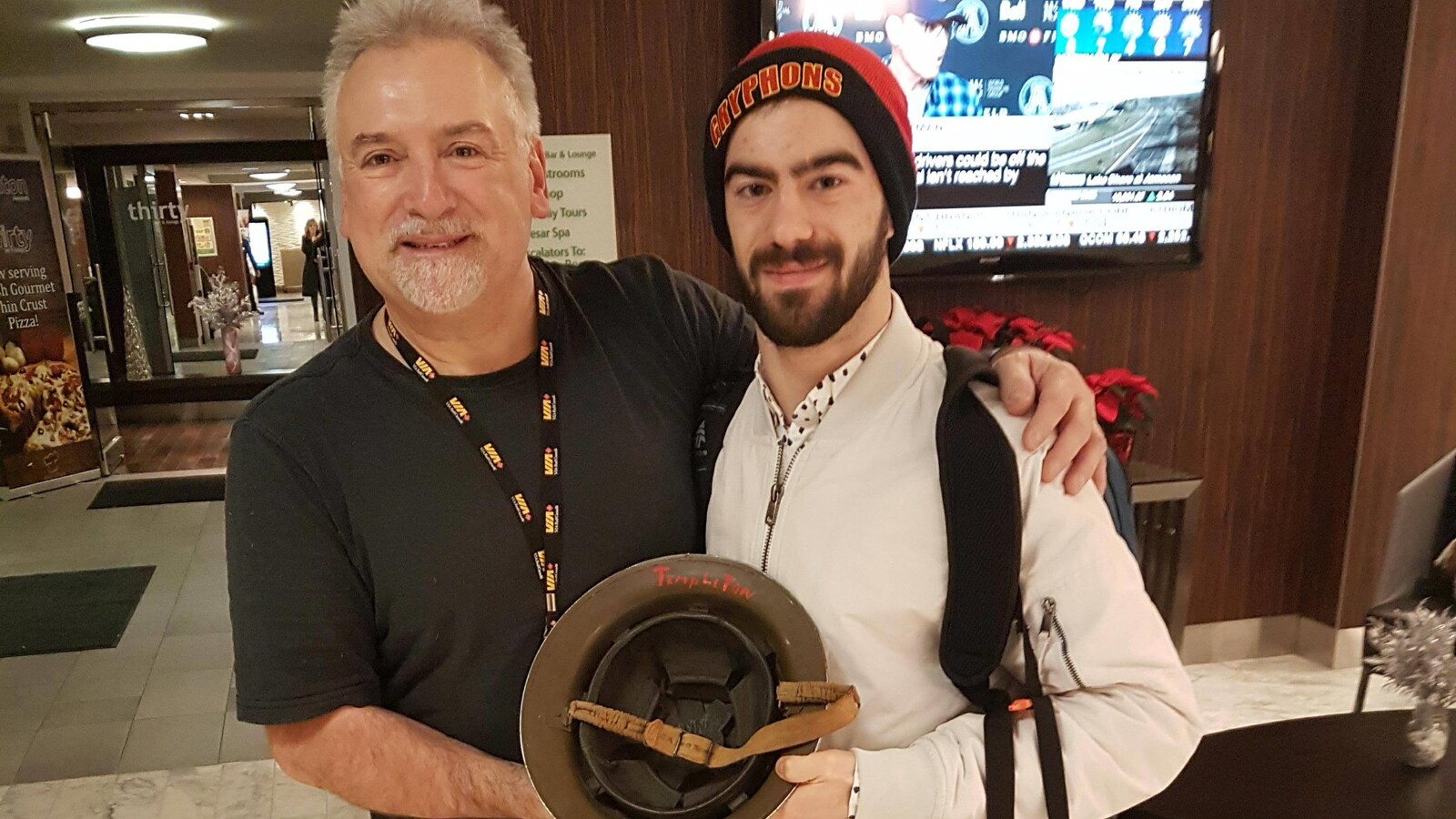 Eugene Restiaux, à gauche, et Phil Di Cecco, à droite, qui tiennent le casque appartenant à l'oncle défunt de M. Restiaux