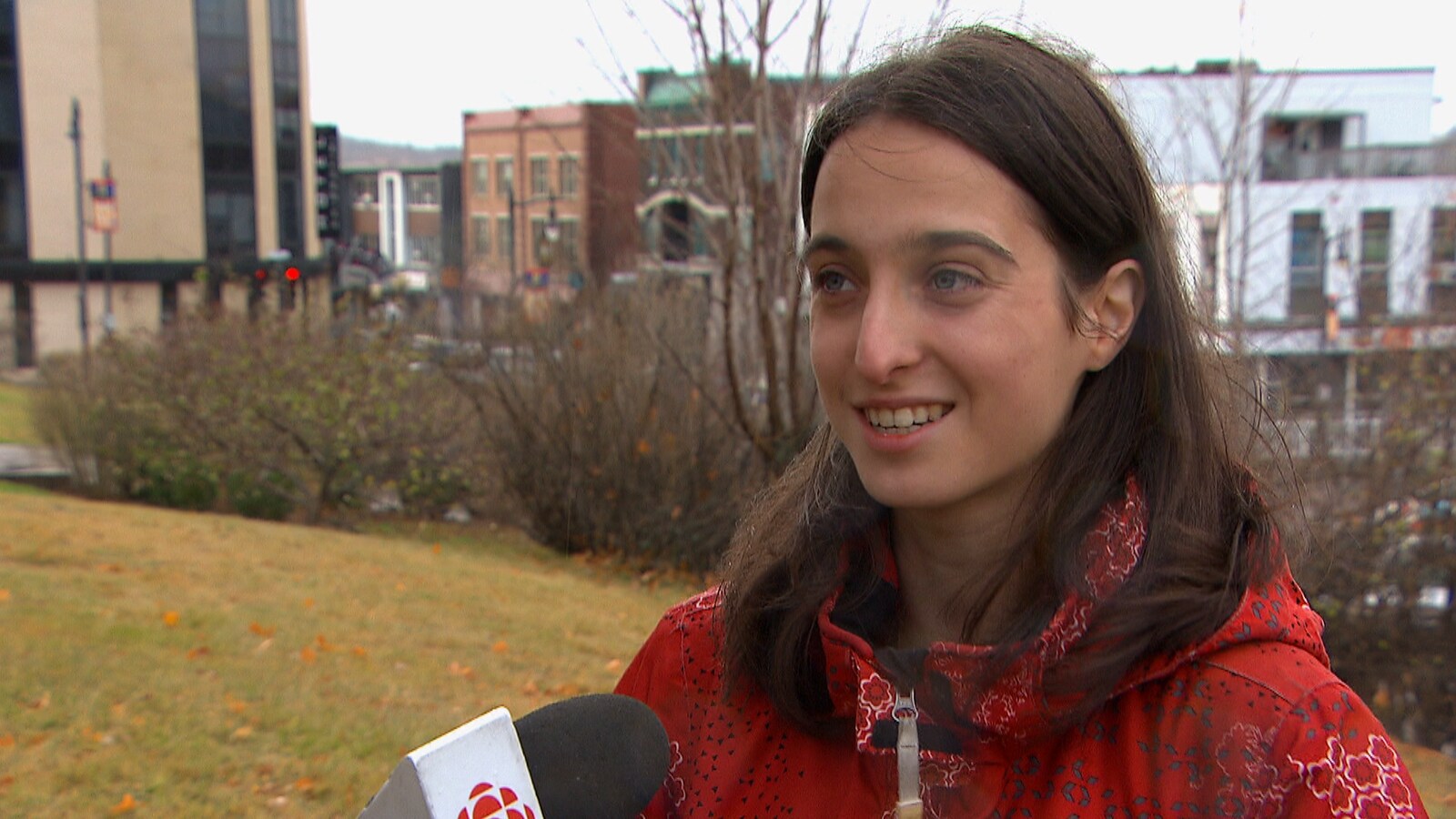 La militante Catherine Bouchard-Tremblay est en entrevue à la caméra dans un parc de Chicoutimi.