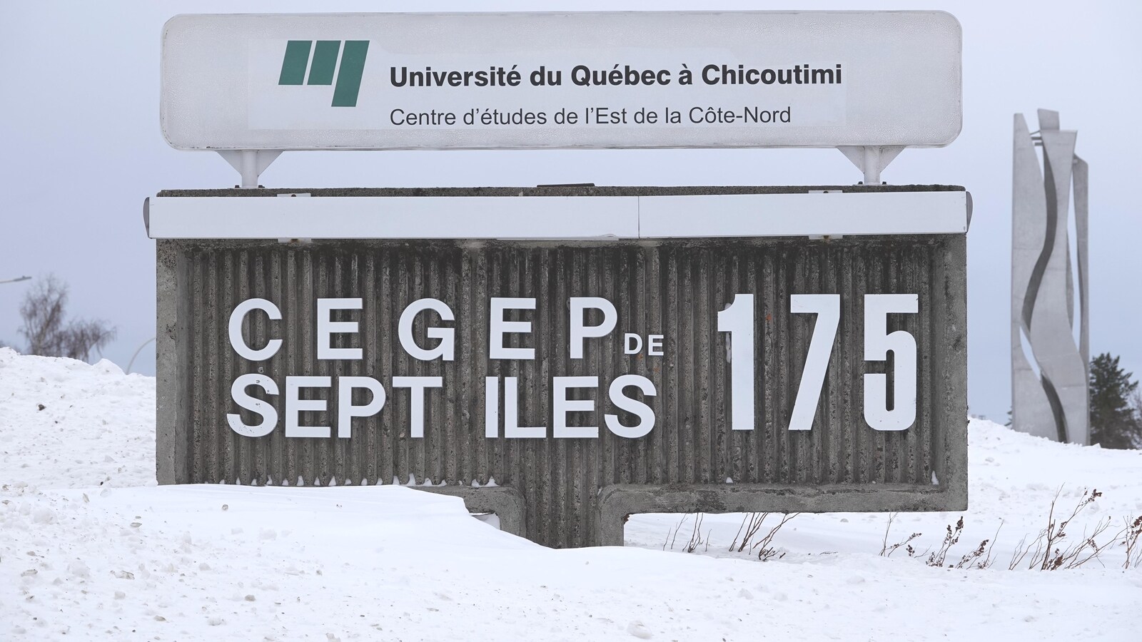 L'enseigne en bordure de rue est entourée de neige.
