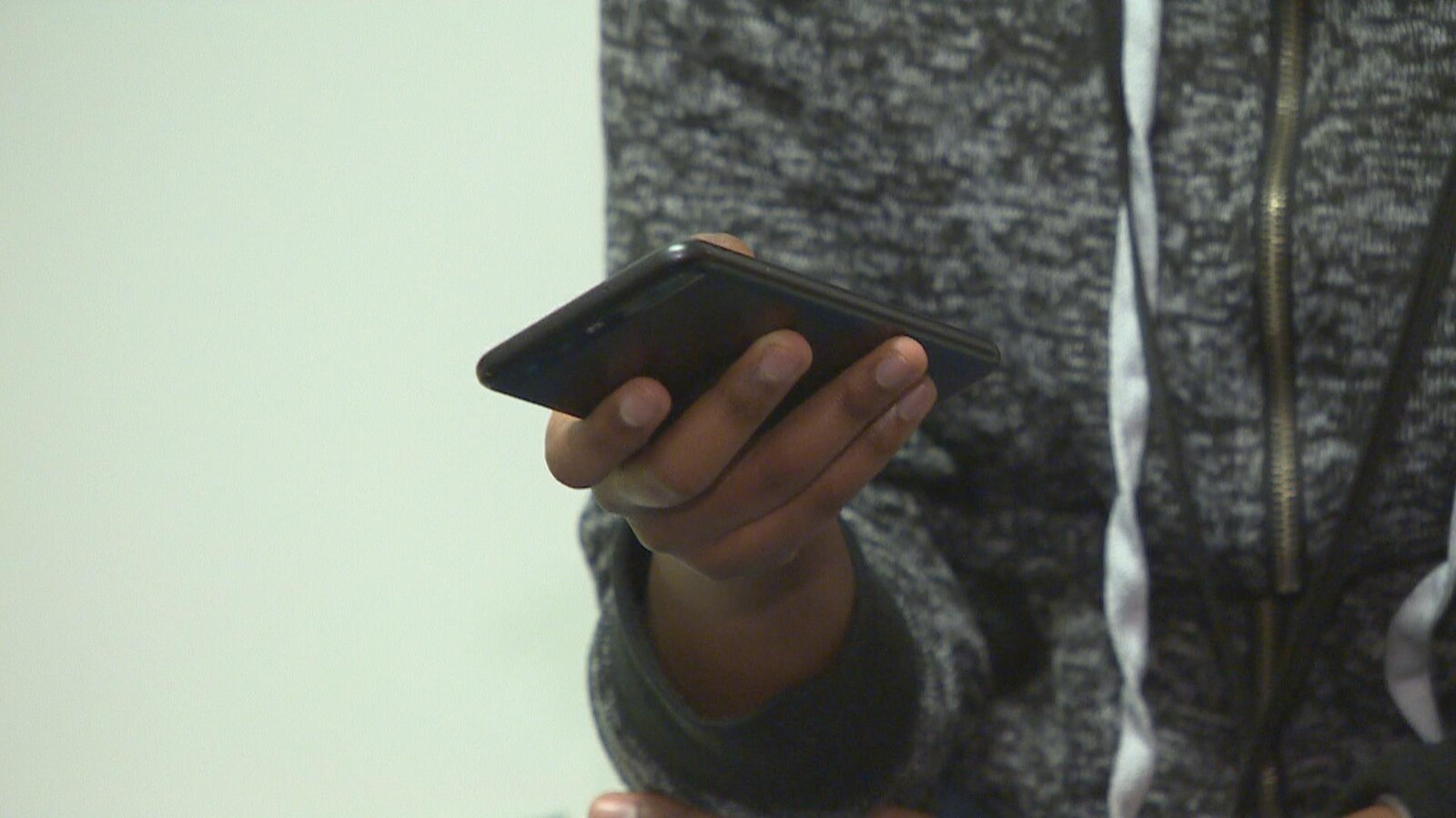 Un téléphone cellulaire dans la main d'un élève.