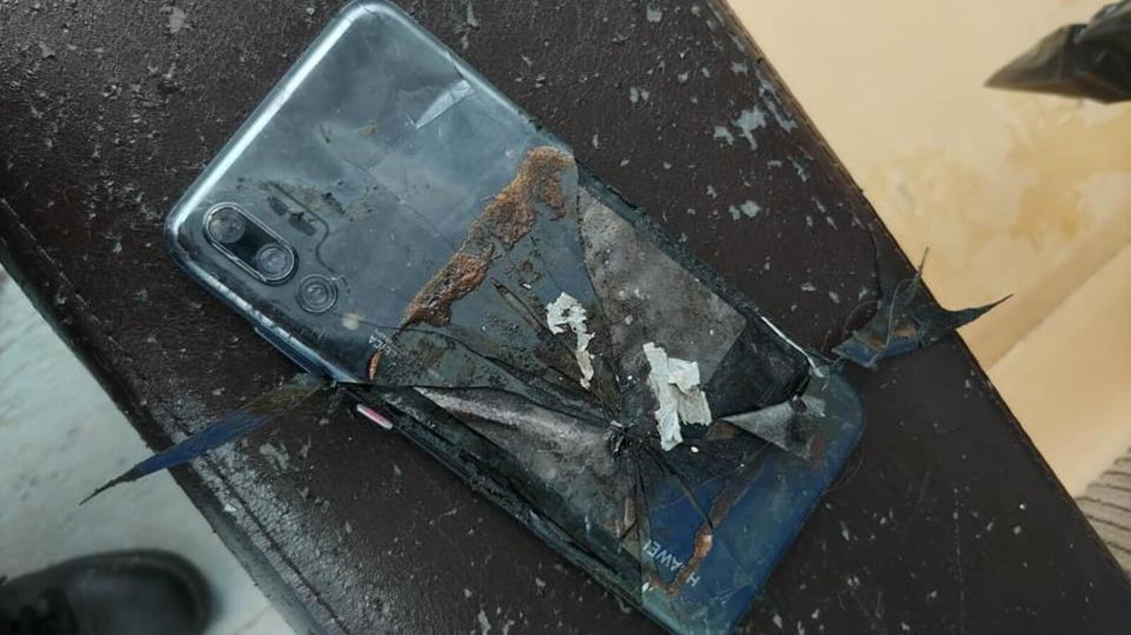 Téléphone cellulaire calciné sur une terrasse extérieure.