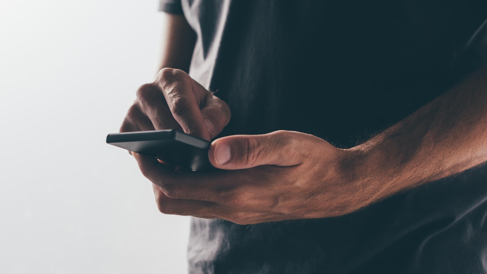 Un homme et son téléphone, sur fond blanc
