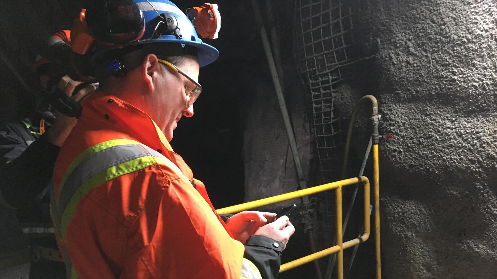 Un mineur utilise un téléphone cellulaire sous terre.