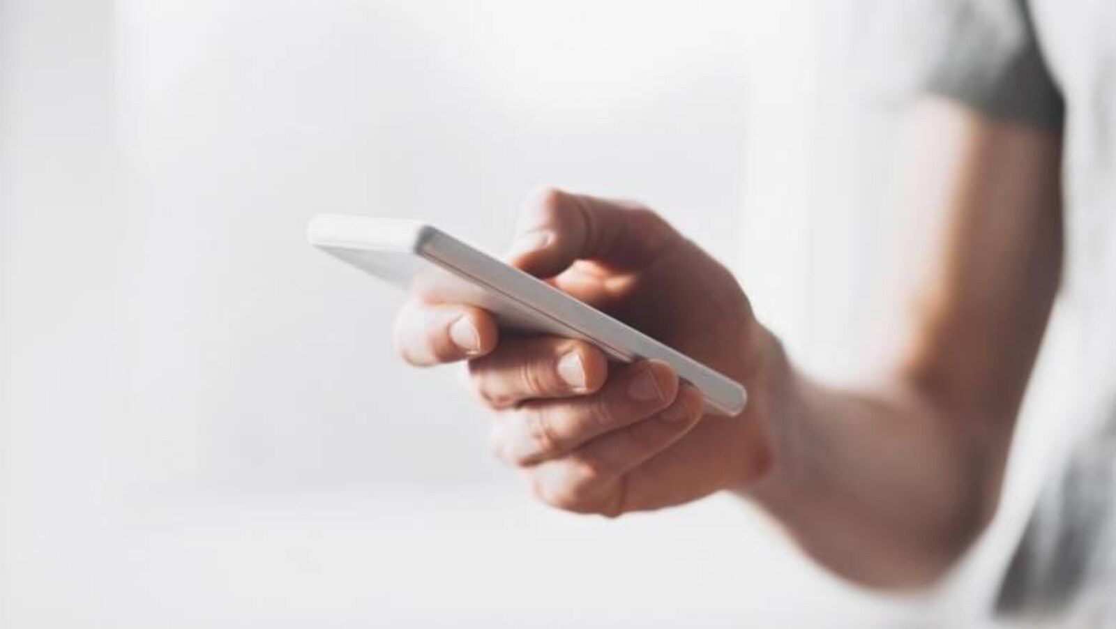 Une personne tient un cellulaire à la main.