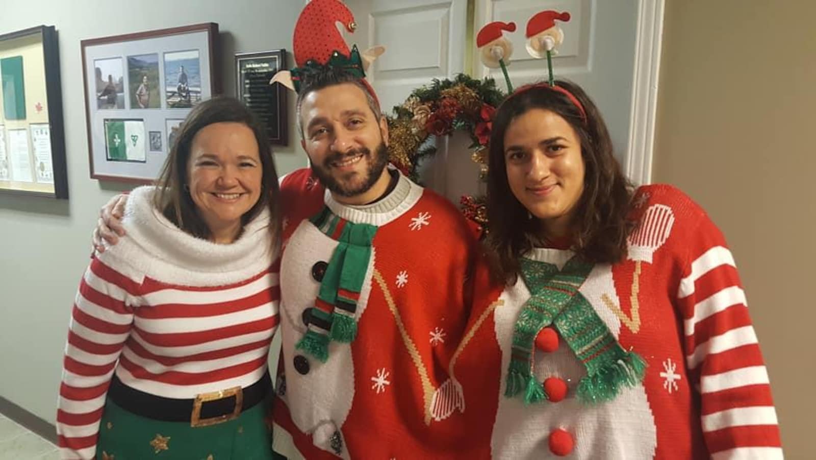 Trois personnes souriantes, habillées selon une thématique de Noël.
