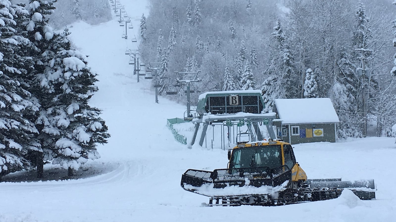 Une dameuse au pied d'une pente de ski du Mont-Édouard