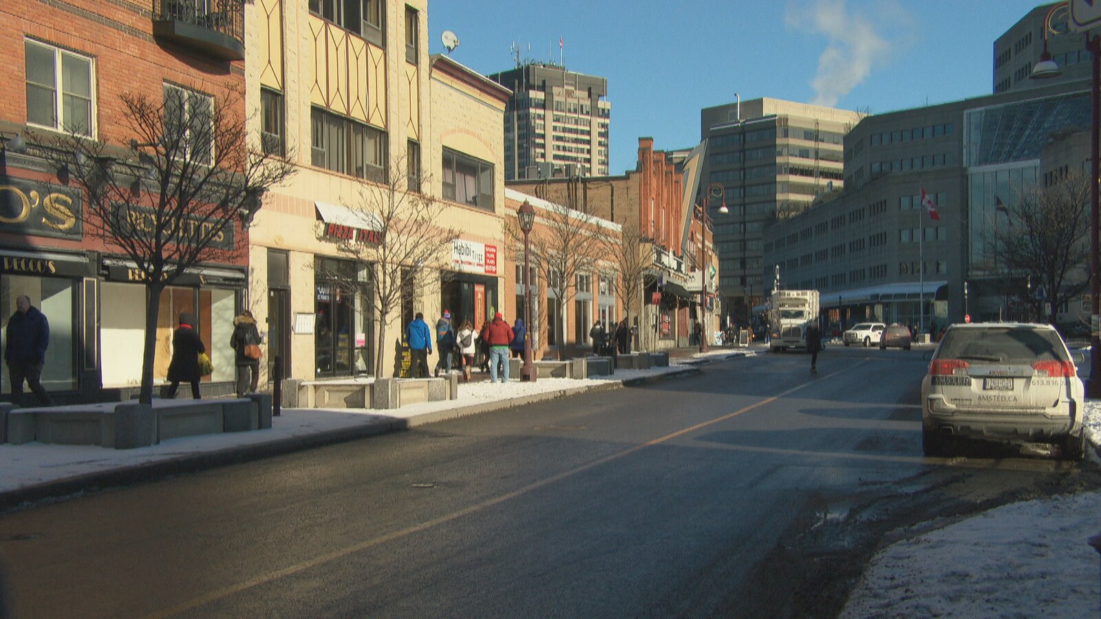 Une rue du secteur de Hull, à Gatineau, où circulent des piétons en hiver.