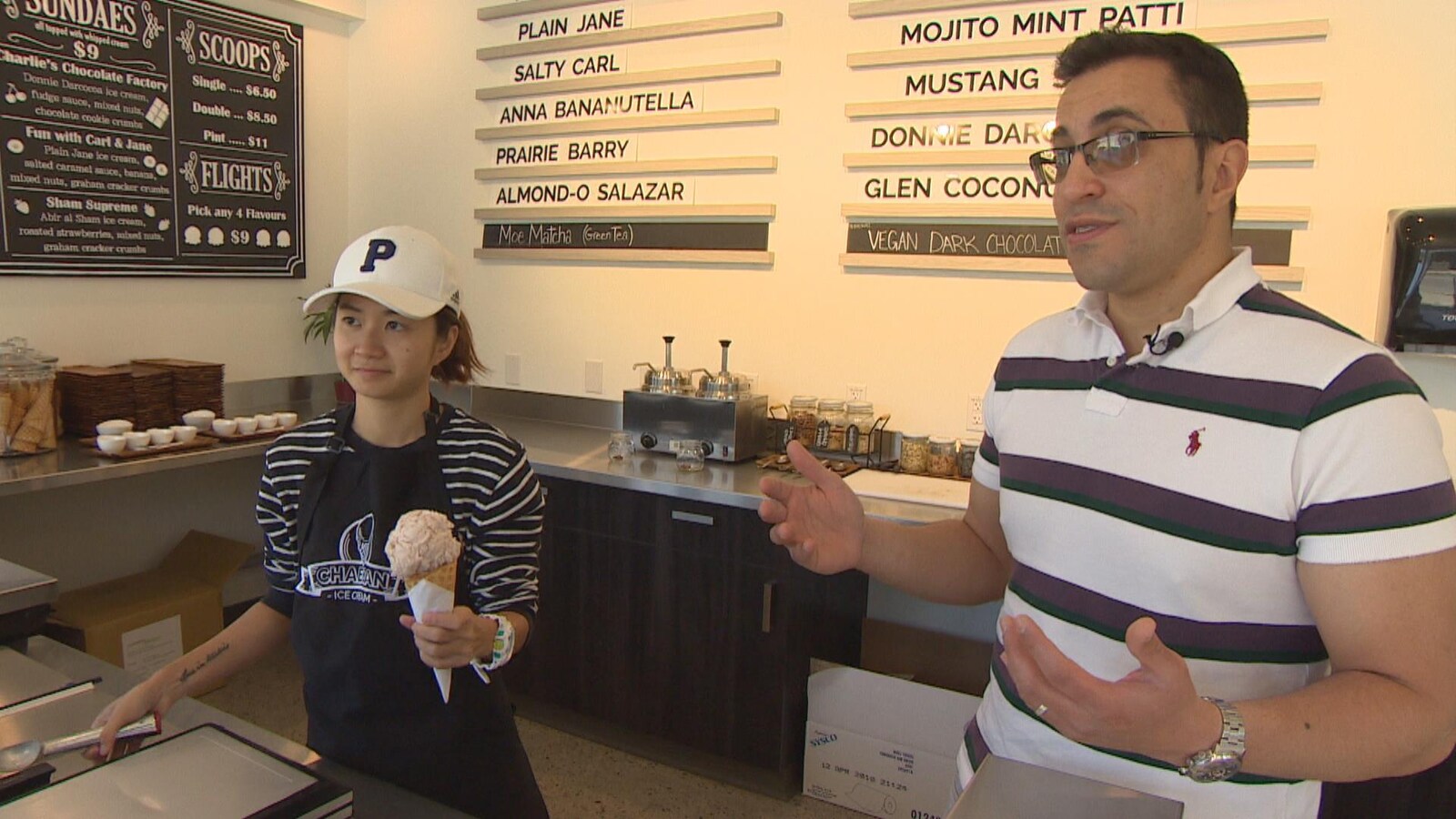Une homme et une femme dans une boutique, la femme tient un cornet de crème glacée.