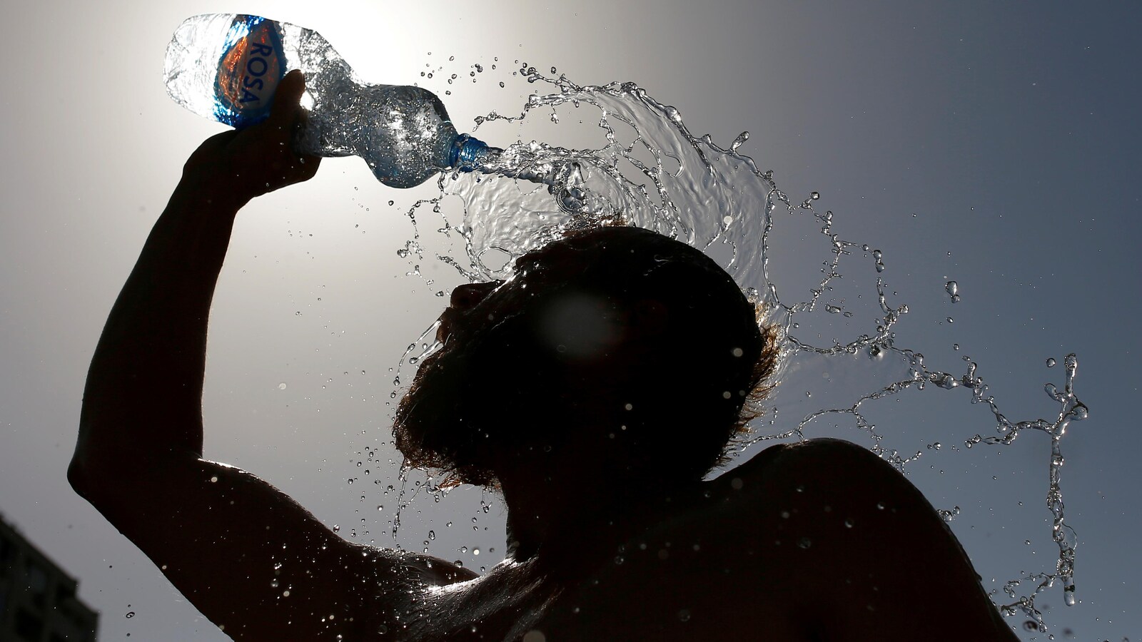 Un homme se rafraîchissant avec une bouteille d'eau