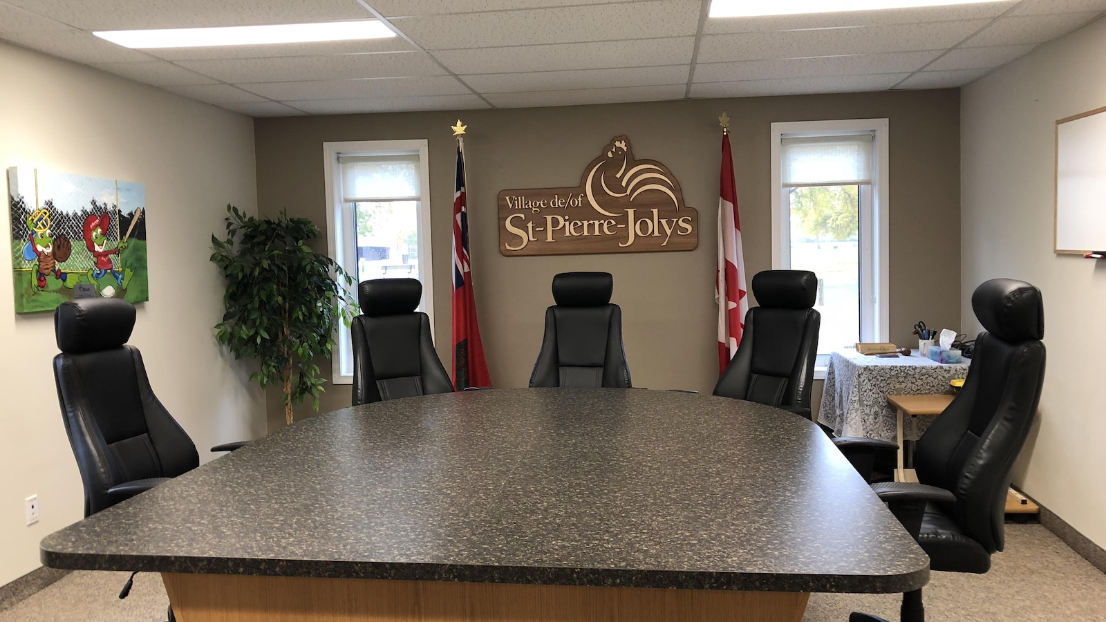 Une chambre de conseil municipal avec cinq sièges vides.