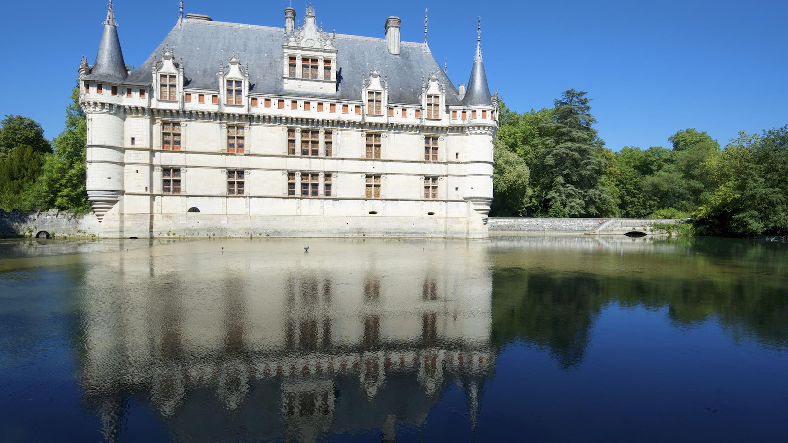 On voit le reflet du château dans l'eau.