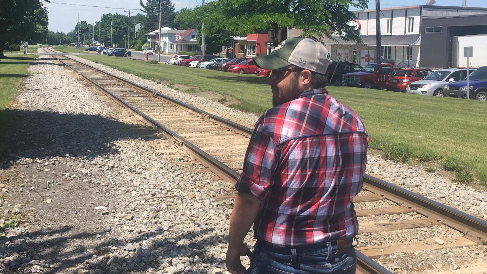 Un homme marche le long d'une voie ferrée.