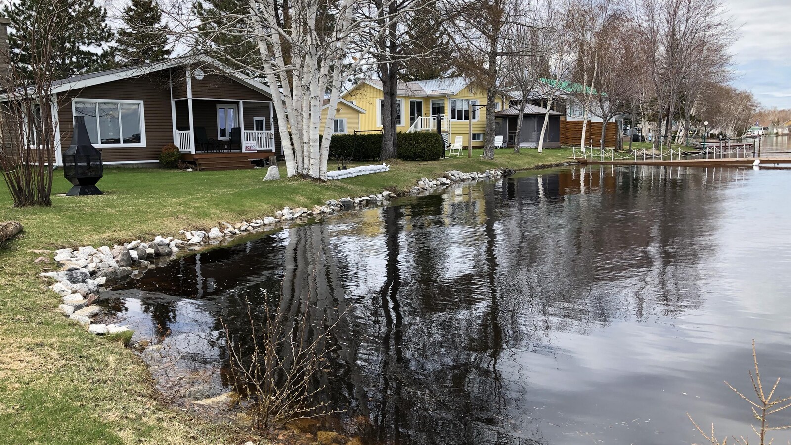 On voit plusieurs maisons situées tout près de l'eau.